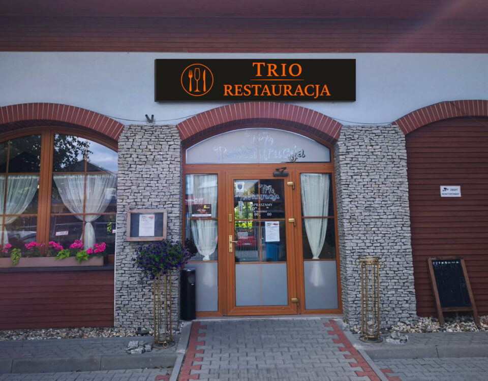 Widok na front Restauracji TRIO w Opolu - przytulna, kamienna fasada z łukowymi oknami i podświetlonym szyldem.
